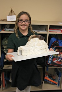traditional charter school student displays model of igloo