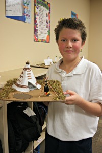 traditional charter school student displays model of teepee