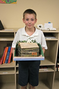 traditional charter school student displays log cabin model
