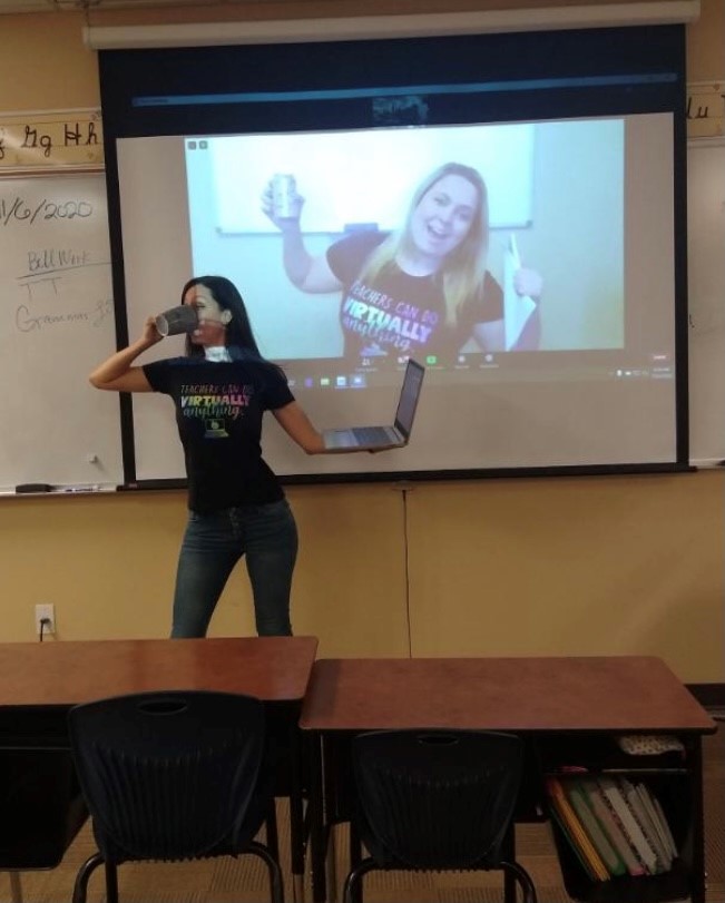 Two young, fun teachers, one in person, one on-screen, wear t-shirts stating 
